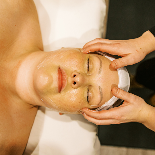 A woman relaxes with her eyes closed while receiving a therapeutic cranial massage designed to reduce headache symptoms.