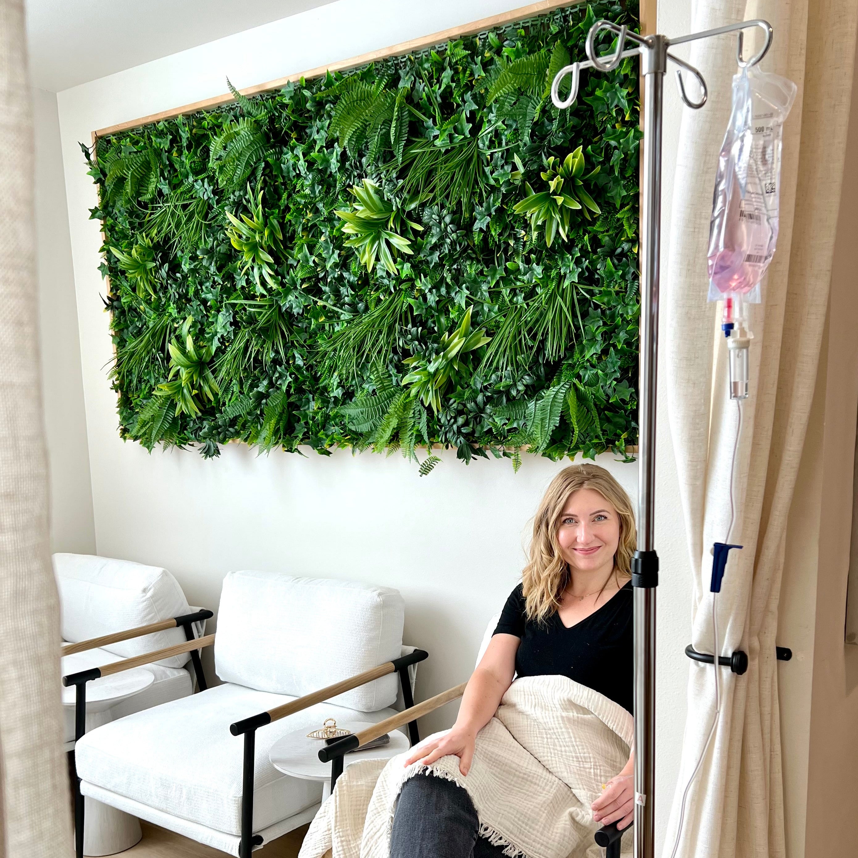 A woman smiles while receiving IV therapy at luxury medspa Pure Skin Wellness Spa