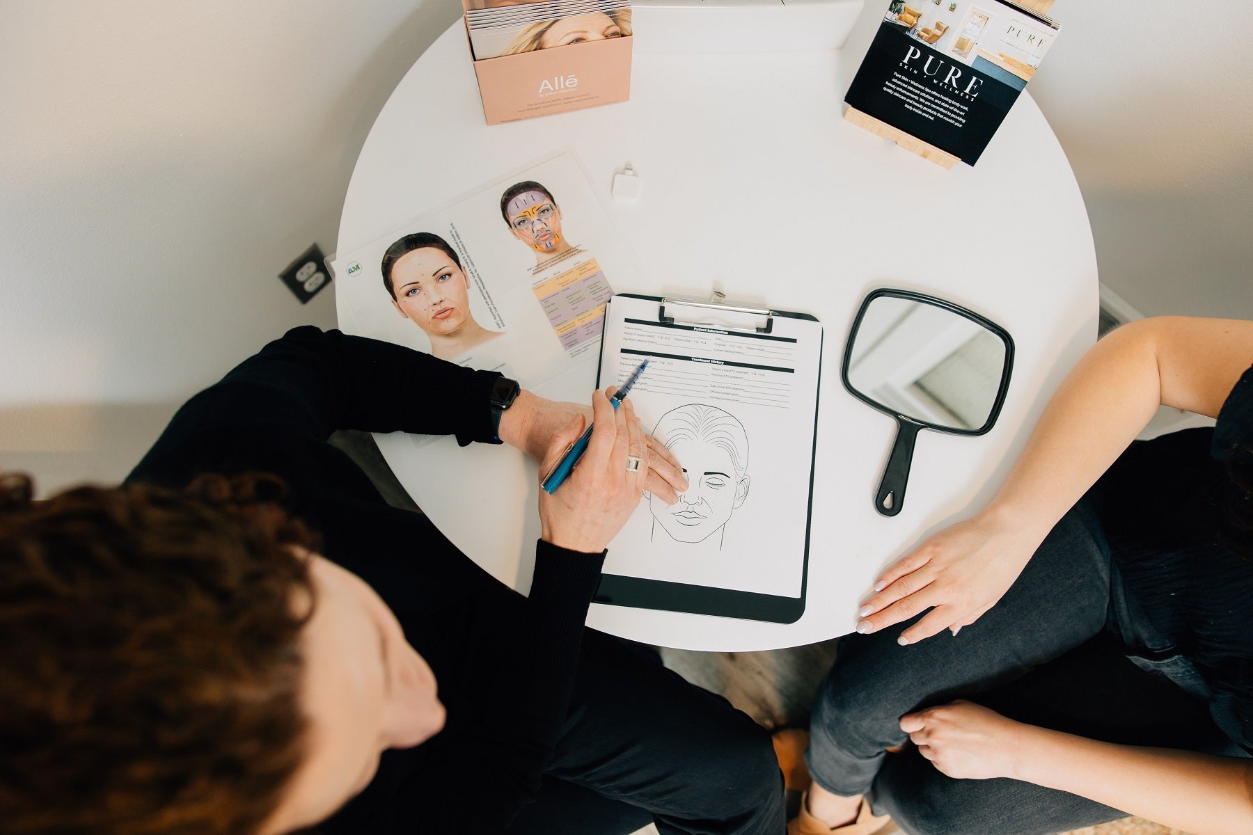 A medspa RN consults with a client regarding skincare goals for botox.