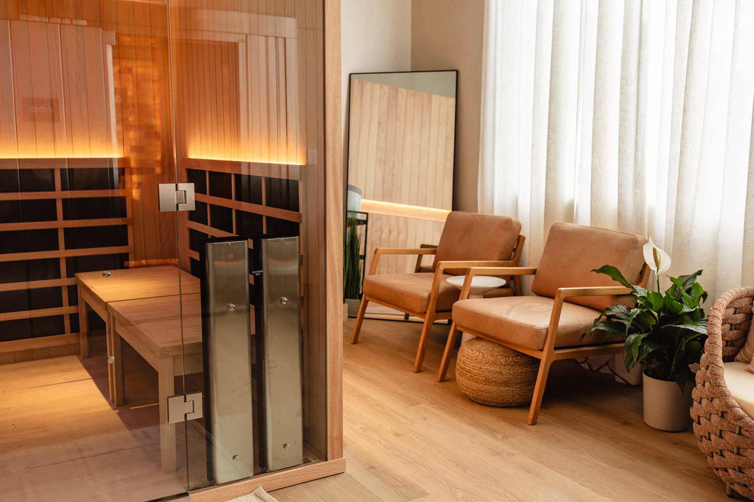 A calming wellness lounge environment features plush seating, verdant plant life, and an infrared sauna.