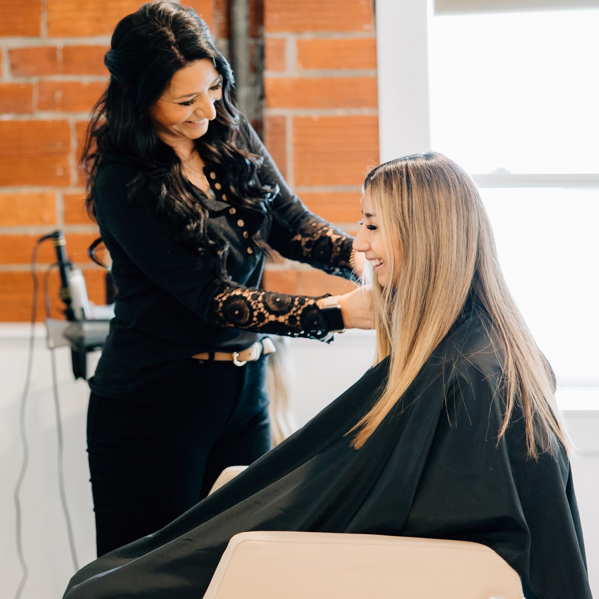 hair stylist laughing and consulting with guest