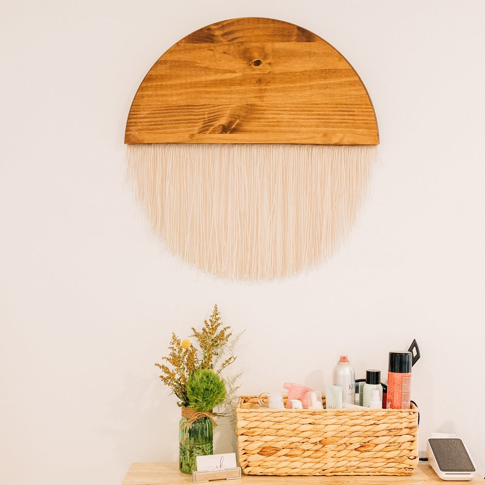 wood and macramé wall art pictured above basket of hair products and tools