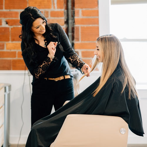 A woman gets her hair cut in an upscale spa hair salon. 