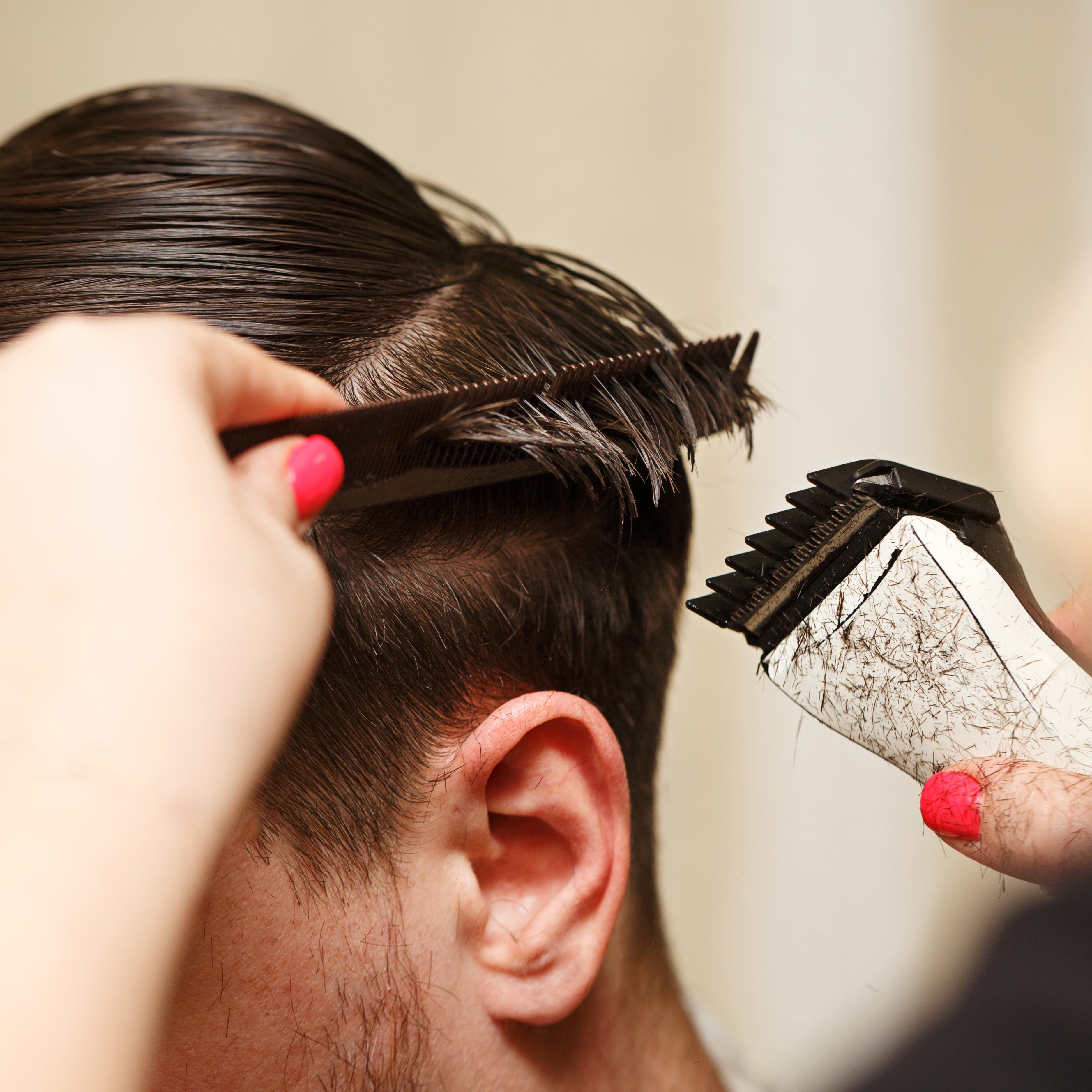 A close up image shows a man's hair during a haircut.